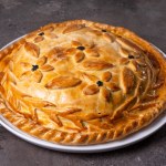 hot homemade chicken pie with filling. pie on the table.