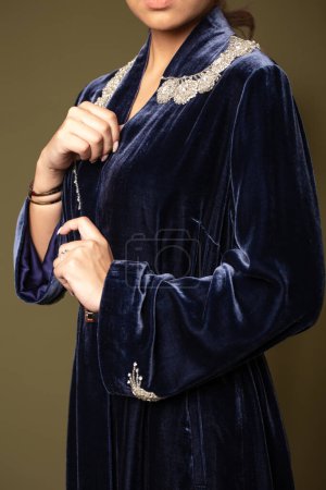 This blue velvet kimono sleeve coat is perfect for formal occasions with intricate embroidery and a beaded collar. Lined with soft satin for comfort, it exudes luxury.