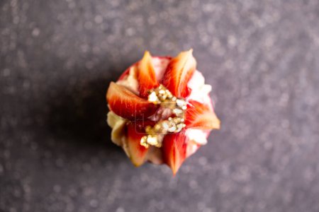 Un primer plano de una tarta de crema de fresa con pan de oro en una mesa de piedra oscura. Elaborado con fresas frescas, crema, corteza de mantequilla.