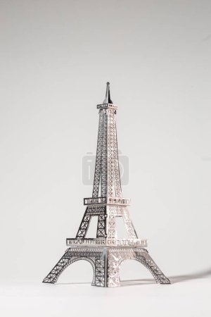 Metallausschnitt des Eiffelturms auf weißem Hintergrund. Gitterdesign unterstreicht Geschicklichkeit und Präzision und schafft komplexe Muster.