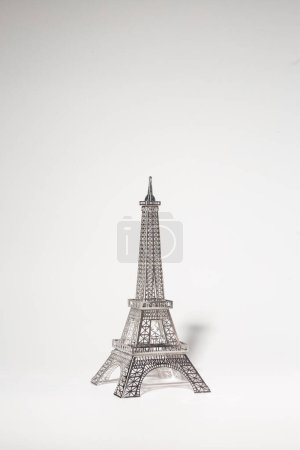 Photo for Metal Eiffel Tower cutout on white background. Lattice design highlights skill and precision, creating intricate pattern. - Royalty Free Image