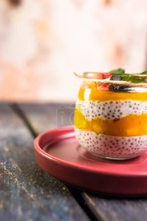 Chia-Pudding mit Mango, gemischten Beeren, Milch, griechischem Joghurt, verschiedenen Früchten und Honig. Tropisch inspiriertes Vergnügen für einen erfrischenden Sommergenuss.