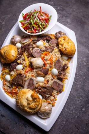Imagen de riego bucal del plato Plov uzbeko con cordero, arroz, zanahorias, cebollas y especias en el plato blanco. Fondo rústico añade autenticidad.