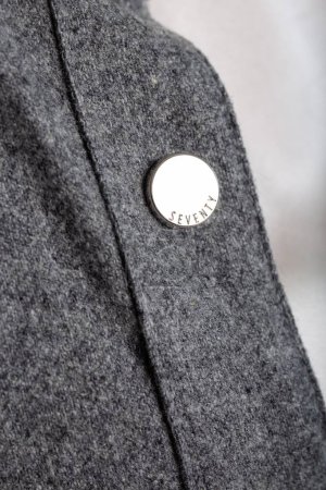 This retro 1970s coat features a central silver button on a gray wool blend fabric, a timeless classic for any wardrobe.