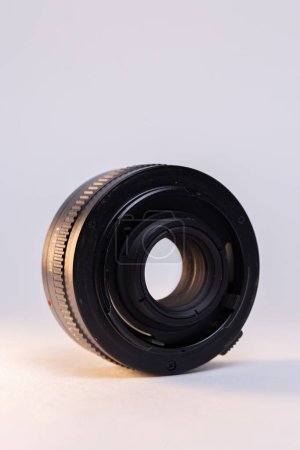Un appareil photo noir convertisseur de téléobjectif sur fond blanc, parfait pour les amateurs de photographie et les professionnels.