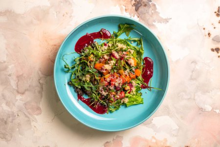 Salad with pumpkin, lettuce, tomatoes, and quinoa. Drizzle with beet sauce and decorate with herbs. Isolated on a white background.