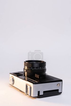 Photo for Vintage film camera with a sleek silver body and a classic black manual focus lens, elegantly displayed against a clean white background. - Royalty Free Image