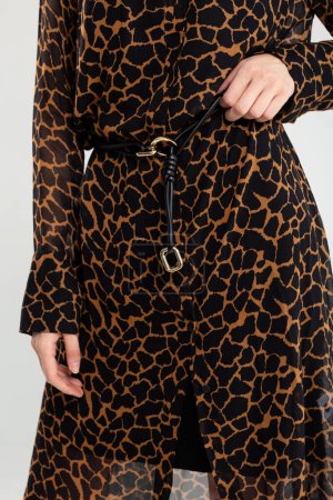 Model flaunts trendy giraffe print shirt dress with black belt. Perfect for casual outings or a night out.
