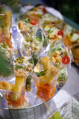 Delicious appetizers on a glass tray for catering event. Mini tacos, bruschetta, savory treats. Perfect for parties, weddings, and more.