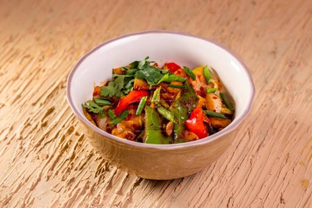 Photo for Healthy, colorful dish with snap peas, green beans, and red bell pepper in a rustic bowl. Served on a wooden table. - Royalty Free Image