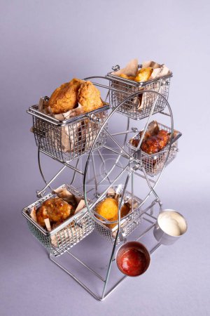 Photo for Experience a delightful assortment of fried goodies on a whimsical ferris wheel, served with an array of delectable dipping sauces. - Royalty Free Image