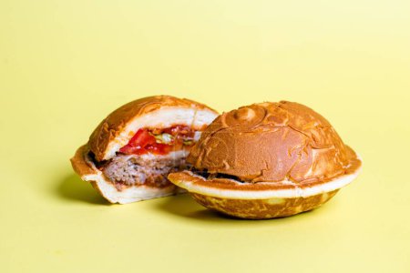 Photo for The round waffle sandwich buns have a golden-brown color and are filled with a beef patty, tomato, cheese, and lettuce. - Royalty Free Image