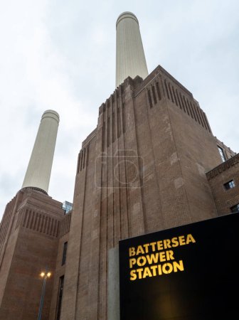 Téléchargez les photos : Londres. Royaume-Uni 11.02.2022. Une vue vers le haut de la centrale électrique de Battersea montrant deux de ses cheminées avec signe de nom au premier plan. - en image libre de droit