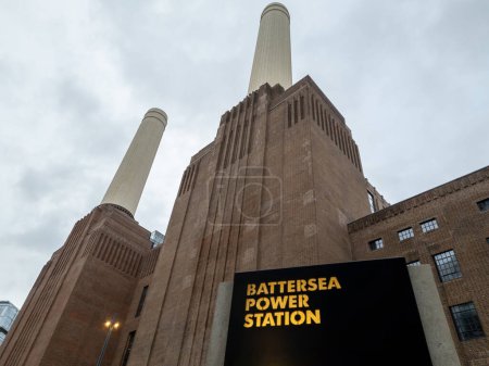 Téléchargez les photos : Londres. Royaume-Uni 11.02.2022. Une vue vers le haut de la centrale électrique de Battersea montrant deux de ses cheminées avec signe de nom au premier plan. - en image libre de droit