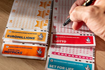 Foto de Londres. Reino Unido 11.20.2022. Una persona que marca los números en un cupón de lotería. - Imagen libre de derechos