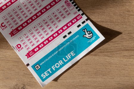 Foto de Londres. Reino Unido 11.20.2022. Primer plano de un conjunto de lotería nacional de por vida jugando cupón. - Imagen libre de derechos