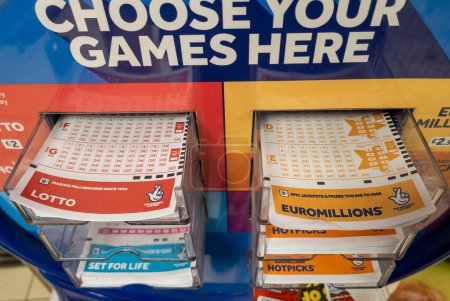 Foto de Londres. Reino Unido 11.20.2022. El stand de la Lotería Nacional en una tienda minorista con varios cupones de juego disponibles. - Imagen libre de derechos