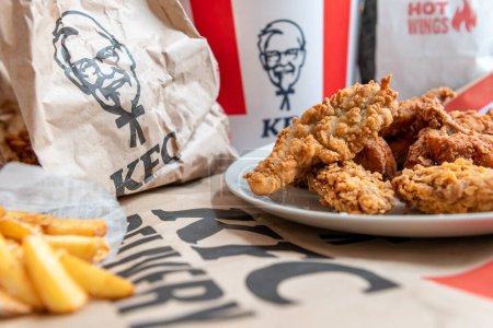 Photo for London. UK- 01.29.2023. A spread on the table of various fried chicken and potato fries from KFC online order delivery to the home. - Royalty Free Image