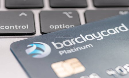 Foto de London. UK- 01.29.2023. A Barclaycard Platinum bank card on top of a laptop computer with a person pressing the option button. - Imagen libre de derechos