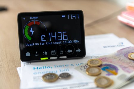 A smart energy meter on household energy bills. Cost of living, rising energy cost concept-stock-photo