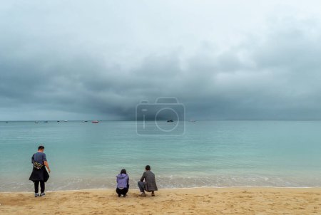Téléchargez les photos : St Ives.Cornwall. Royaume-Uni 10.01.2023. Touristes sur la plage de Porthminister regardant vers la mer avec une tempête entrante. - en image libre de droit