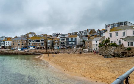 Foto de St. Ives.Cornwall. Reino Unido 10.01.2023. Una vista de la pequeña playa y edificios a lo largo de la carretera de la costa The Wharf. - Imagen libre de derechos