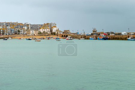 Téléchargez les photos : St Ives.Cornwall. Royaume-Uni 10.01.2023. Vue lointaine de la jetée de Smeaton et du port par temps de pluie nuageux. - en image libre de droit