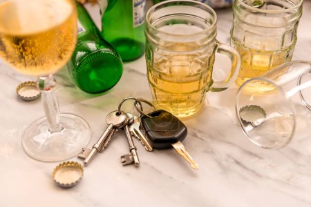 Téléchargez les photos : Un ensemble de clés de voiture sur une table pleine de verres de boissons alcoolisées et de bouteilles. Concept de conduite d'alcool. - en image libre de droit