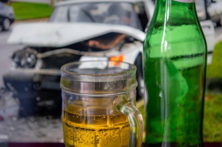Téléchargez les photos : Un concept de conduite en état d'ébriété avec une pinte et des bouteilles de bière et une photo d'une voiture écrasée en arrière-plan. - en image libre de droit