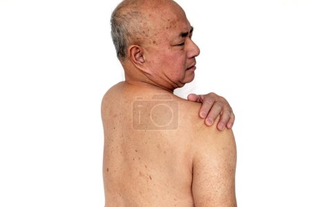 Téléchargez les photos : Un homme âgé avec une expression douloureuse souffrant de douleur à l'épaule isolé dans un fond blanc - en image libre de droit
