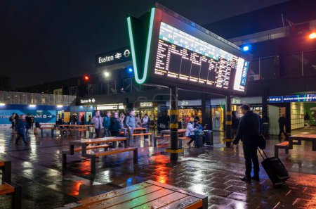 Foto de Londres. Reino Unido - 01.23.2024. Una vista nocturna de la sala de espera fuera de la estación de Euston con pantalla de información del tren. - Imagen libre de derechos