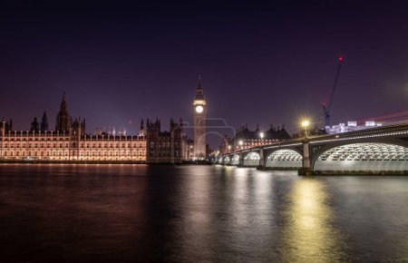 Téléchargez les photos : Londres. Royaume-Uni 02.04.2024. Vue de nuit sur le palais de Westminster, Big Ben et le pont de Westminster projetant des reflets lumineux sur la Tamise. - en image libre de droit