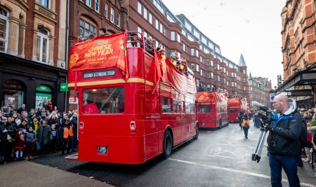 Téléchargez les photos : Londres. Royaume-Uni 02.11.2024. Les bus emblématiques de Londres Route Master dans le défilé de célébration du Nouvel An chinois à China Town avec une foule énorme bordant la rue. - en image libre de droit