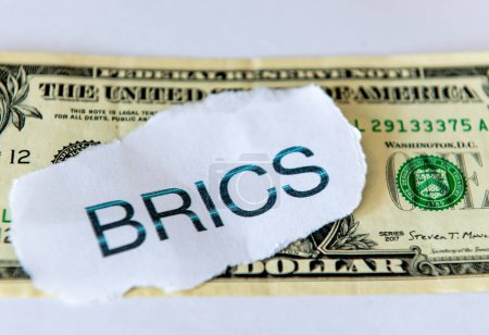 A dedollarisation concept with the word BRICS on top of a US dollar bill  isolated in white.