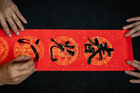 Foto de Writing Chinese calligraphy with word meaning "Good Fortune" for Taditional Chinese new year - Imagen libre de derechos