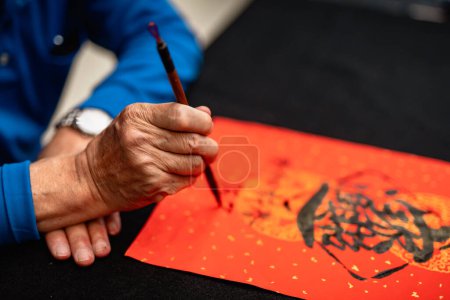 Téléchargez les photos : Writing Chinese calligraphy with word meaning "Good Fortune" for Taditional Chinese new year - en image libre de droit