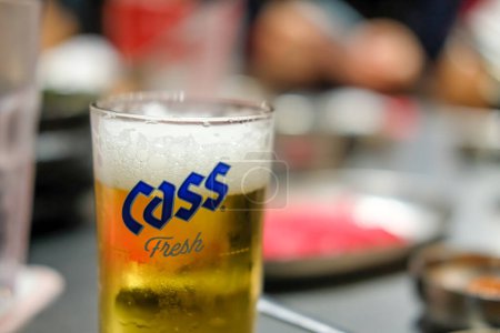 Téléchargez les photos : Bangkok, Thaïlande - 8 mai 2022 : Un verre de Cass Fresh, une bière de style lager brassée par Oriental Brewery Co., Ltd à Séoul, Corée du Sud. Il est célèbre pour les jeunes buveurs de bière grand public - en image libre de droit
