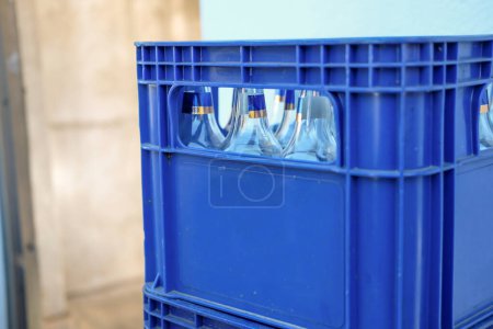 Foto de Caja de cerveza de plástico azul con botellas vacías - Imagen libre de derechos