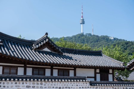 Photo for Traditional Korean building in Namsangol Hanok village, with view of N Seoul Tower or Namsan Tower in Seoul, South Korea. - Royalty Free Image