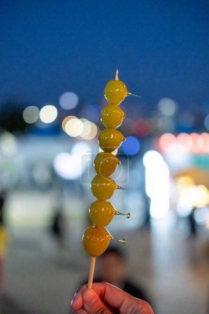 Photo for Muscat grape Tanghulu or Tang Hulu. It is a grape dipped with sugar coating on a skewer. It is a traditional Northern Chinese snack. - Royalty Free Image