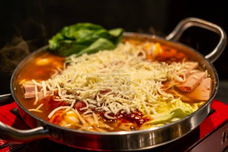 Koreanischer Hot Pot, Ramyeon und Tteokbokki in Kimchi-Suppe mit Gemüse, Fleisch und Käse darüber