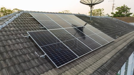 Foto de Paneles de rejilla solar en la azotea de la casa doméstica en Asia por la noche. Vista aérea del dron. Tecnología de energía perpetua natural, energía sostenible limpia, concepto de estilo de vida de cero residuos. - Imagen libre de derechos