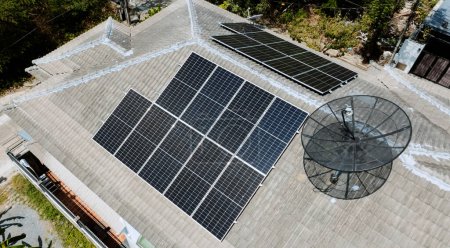 Foto de Paneles de rejilla solar en la azotea de la casa doméstica en Asia en el soleado día de verano. Vista aérea del dron. Tecnología de energía perpetua natural, energía sostenible limpia, concepto de estilo de vida de cero residuos. - Imagen libre de derechos