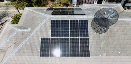 Foto de Paneles de rejilla solar en la azotea de la casa doméstica en Asia en el soleado día de verano. Vista aérea del dron. Tecnología de energía perpetua natural, energía sostenible limpia, concepto de estilo de vida de cero residuos. - Imagen libre de derechos