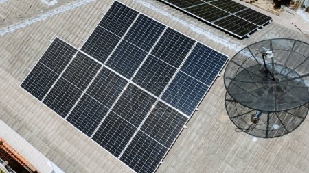 Téléchargez les photos : Panneaux solaires sur le toit de la maison domestique en Asie le jour ensoleillé de l'été. Vue aérienne du drone. Technologie d'énergie naturelle perpétuelle, énergie propre et durable, concept de mode de vie zéro déchet. - en image libre de droit