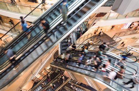 Photo for Motion blur Asian people customer transport on escalator at urban shopping mall in Hong Kong. Department store business, financial economy, Asia city life, tourist traveler lifestyle. High angle view - Royalty Free Image