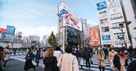 Photo for Tokyo, Japan - Dec 2, 2022: Crowded people walk cross road, car traffic transportation in Shinjuku shopping business district. Tourist attraction tourism landmark, Asia transport or Asian city life - Royalty Free Image