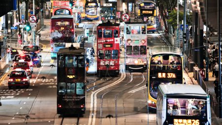 Téléchargez les photos : Central, Hong Kong - 6 juin 2023 : Voiture, bus, transport en taxi, peuple chinois, foule Les navetteurs asiatiques traversent la route la nuit. Tourisme de voyage, mode de vie des transports en Asie ou vie urbaine - en image libre de droit