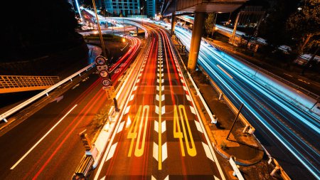 Photo for Long Exposure light trail of car traffic transportation on road, highway, bridge in Tokyo Japan at night. Speed limit sign on ground. Japanese transport culture, Asia commuter, Asian city night life - Royalty Free Image