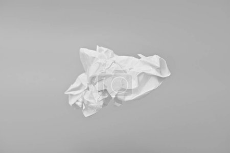 Crumpled sheet of paper on gray background